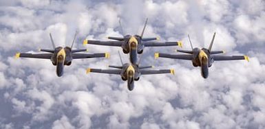 The US Navy (USN) flight demonstration team the "Blue Angels," F/A-18A Hornet aircraft fly in diamond formation as they transits across the Pacific Ocean for an air show at Marine Corps Base Hawaii in Kaneohe Bay, Hawaii