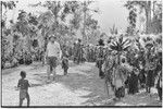 Pig festival, singsing, Kwiop: Edwin Cook walks past spectators and decorated dancers