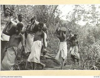 1943-06-28. NEW GUINEA. WAU-MUBO AREA. NATIVE CARRIERS SET OUT ALONG THE TRACK IN THE WAU-MUBO AREA, CARRYING SUPPLIES TO FORWARD AREAS. (NEGATIVE BY G. SHORT)