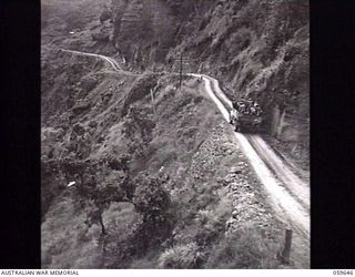 DONADABU, NEW GUINEA. 1943-11-07. VIEW OF THE ROUNA FALLS ROAD WINDING UP THE MOUNTAINSIDE. NOTE THE VEHICLE LOADED WITH TROOPS IN THE BACK