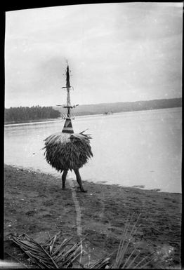 Dukduk standing on a beach, Rabaul Harbour, New Guinea, ca. 1929 / Sarah Chinnery