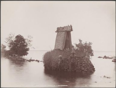 A man and child standing in front of the islet shrine at Tunduo, Java, Solomon Islands, 1906 / J.W. Beattie