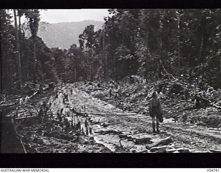 BULLDOG ROAD, NEW GUINEA. 1943-07-09. A MUDDY SECTION OF THE ROAD LEADING TO THE MOUNTAINS BETWEEN THE 4 AND 5 MILE POINTS THAT HAD TO BE COVERED WITH CORDUROY