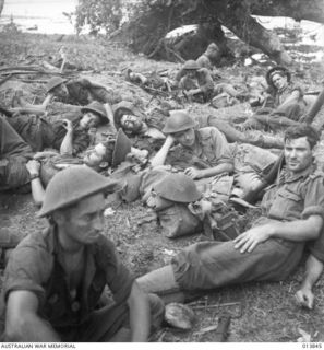 1942-12-16. PAPUA. FALL OF GONA. AUSTRALIANS TROOPS REST AFTER THE CHARGE WHICH CLEANED THE JAPANESE OUT OF GONA. TIRED AND WORN OUT, THE TROOPS DROPPED FOR REST EVEN THOUGH THEY WERE RIGHT IN THE ..