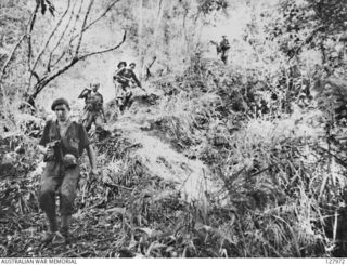 NAMLING, NEW GUINEA. 1943-07-19. RETURNING ALONG A STEEP SLOPE AFTER BEING IN ACTION IN THE "GRAVEYARD" AREA, NORTH OF ORODUBI, MEMBERS OF 2/3RD AUSTRALIAN INDEPENDENT COMPANY. (FILM STILL)