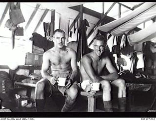 RABAUL, NEW GUINEA. 1941-12. AN UNIDENTIFIED CORPORAL (LEFT) AND NX60128 GUNNER LES J. LYONS, 17TH ANTI-TANK BATTERY, ROYAL AUSTRALIAN ARTILLERY, IN THEIR BARRACKS. (DONOR T. O'BRIEN)