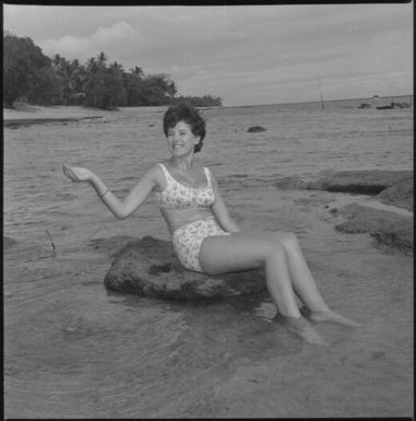 Miss Maglia wearing a bikini and sitting on a rock in the sea at Suva, Fiji, 22 February 1966 [1] John Mulligan