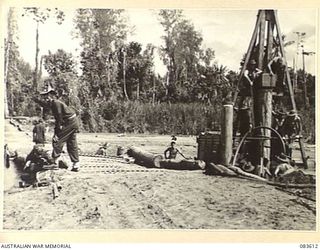 DRINIUMOR RIVER, NEW GUINEA. 1944-11-23. THE NEW BRIDGE UNDER CONSTRUCTION BY TROOPS OF THE 2/8 FIELD COMPANY, ROYAL AUSTRALIAN ENGINEERS, ALONGSIDE THE OLD BRIDGE