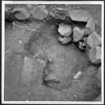 Penu in situ in round pit, with firepit belonging to square house, above it. Round pit