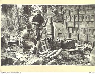 LAE, NEW GUINEA. 1944-03-29. PERSONNEL OF THE RETURNED STORES AMMUNITION DEPOT, 103RD FIELD AMMUNITION DEPOT, AMONG DAMAGED AMMUNITION LEFT BEHIND BY THE ADVANCING 7TH AUSTRALIAN DIVISION. THE ..