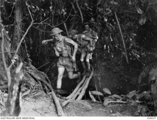 PAPUA, NEW GUINEA. 1942-07. IN THE HEART OF THE JUNGLE. TROOPS OF AN AUSTRALIAN INFANTRY PATROL CROSSING A CREEK