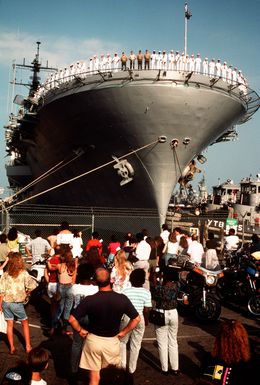 Crew members man the rail aboard the amphibious assault ship USS GUAM (LPH-9) as the vessel prepares to depart for the Persian Gulf in response to Iraq's invasion of Kuwait