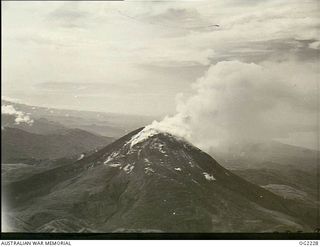 NEAR TOROKINA, BOUGAINVILLE ISLAND, SOLOMON ISLANDS. 1945-01-28. AERIAL VIEW OF THE FAMILIAR LANDMARK BY WHICH RAAF PILOTS MAY CHECK THEIR BEARINGS IS THE SMOULDERING ACTIVE VOLCANO MOUNT BAGANA. ..