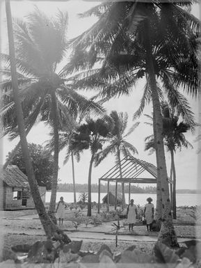 [Three Polynesian women standing along a coastal pathway]