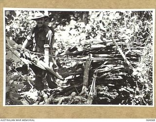 NAMBARIWA, NEW GUINEA. 1944-01-21. AUSTRALIAN ARMY PERSONNEL ADDING TO THE STACK OF RIFLES, MORTARS, LIGHT MACHINE GUNS AND MEDIUM MACHINE GUNS WHICH WERE ABANDONED BY THE JAPANESE FORCES WHEN THEY ..