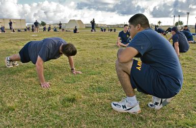 At Yigo, Guam (GU), US Navy (USN) Sailors assigned to the "Island Knights" of Helicopter Sea Combat Squadron 25 (HSC-25) gather around the track, where they prepare themselves for the Navy's semi-annual physical fitness assessment