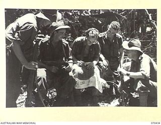 WEBER POINT, NEW GUINEA. 1944-02-14. MEMBERS OF THE 30TH INFANTRY BATTALION AUTOGRAPHING A JAPANESE FLAG THEY CAPTURED AT SINGOR. PERSONNEL ARE:- W96502 PRIVATE E.T. ROBINSON ( ); WX36635 PRIVATE ..
