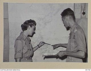 LAE, NEW GUINEA. 1945-05-15. SERGEANT R. HART (1), WITH MAJOR L.J. HERBERT (2) CHECKING INTELLIGENCE POSITIONS ON BATTLE AREAS. SERGEANT HART IS ONE OF A GROUP OF AUSTRALIAN WOMEN'S ARMY SERVICE ..