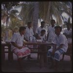 Fijian people gathered outside around a table, Castaway Island, Fiji, 1965 / Michael Terry