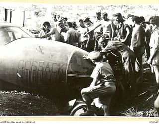 PORT MORESBY, PAPUA, 1942-07-25. US AIR FORCE 22ND BOMB GROUP PERSONNEL INSPECTING THE DAMAGE TO A MARAUDER (B26) BOMBER AIRCRAFT "COSSACK" WHICH MADE A FORCED LANDING ON THE AIRFIELD AT SEVEN MILE ..