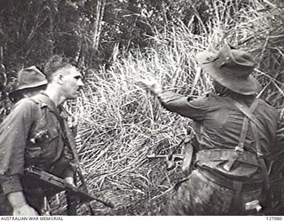 ORODUBI, NEW GUINEA. 1943-07-29. MEMBERS OF 2/3RD AUSTRALIAN INDEPENDENT COMPANY RECEIVING INSTRUCTIONS DURING THE ATTACK ON "TIMBERED KNOLL". (FILM STILL)