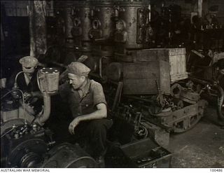Port Moresby, New Guinea. 1944-05-30. Members of 1 Watercraft Workshop, Australian Electrical and Mechanical Engineers (AEME) overhauling marine engines in the unit engine shop
