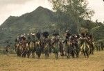 Men stand in a circle while chanting about past and future undertakings