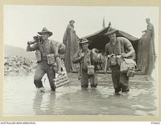 JACQUINOT BAY, NEW BRITAIN. 1944-11-04. TROOPS OF A COMPANY, 14/32ND AUSTRALIAN INFANTRY BATTALION DISEMBARKING FROM LANDING CRAFT OF THE 594TH ENGINEER BOAT AND SHORE COMPANY, UNITED STATES ARMY ..