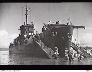 MILNE BAY, NEW GUINEA. 1943-07-12. 29TH AUSTRALIAN INFANTRY BRIGADE, 5TH AUSTRALIAN DIVISION, EMBARK ON NEW AMERICAN LANDING CRAFT (27) FOR BUNA, AT GILI GILI. "ROUND ROBIN" LOADING STORES