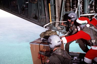 Three crewmen, one dresses as Santa, push boxes out of a 374th Airlift Squadron C-130 Hercules aircraft while delivering gifts to islanders of the Federated States of Micronesia. Flown by crews from the 345th and the 21st Airlift Squadrons, the C-130 is participating in Christmas Drop '92, the 40th anniversary of the humanitarian effort. Every Christmas since 1952, food, clothing, tools and toys donated by residents of Guam have been delivered by air to 40 Micronesian islands
