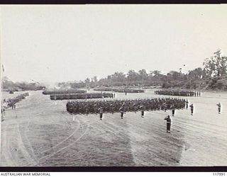 TOROKINA, BOUGAINVILLE. 1945-10-29. PERSONNEL OF 4TH BASE SUB AREA GIVE EYES RIGHT AS THEY PASS THE SALUTING BASE WHERE THE COMMANDER IN CHIEF, AUSTRALIAN MILITARY FORCES, TAKES THE SALUTE DURING A ..
