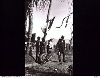 DUMPU, NEW GUINEA. 1943-10-15. A SLIGHTLY WOUNDED DIGGER, SX9025 LANCE CORPORAL H. G. MULRONEY, WALKS WITH THE AID OF A STICK AT 2/6TH AUSTRALIAN FIELD AMBULANCE WITH "E" SURGICAL TEAM. NATIVES ..