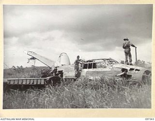 RABAUL, NEW BRITAIN. 1945-09-29. MEMBERS OF HEADQUARTERS 11 DIVISION AT VUNAKANAU AIRSTRIP EXAMINING WRECKED JAPANESE BOMBER