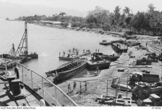 MALAHANG BEACH, NEW GUINEA. 1944-05-14. ALLIED AND AUSTRALIAN TROOPS ON THEIR REST DAY ON THE BEACH NEAR LAE. THE REMAINS OF THE JAPANESE MERCHANT SHIP MYOKO MARU WHICH WAS BEACHED AFTER RECEIVING ..