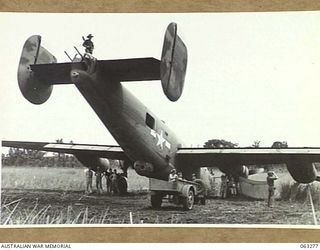 FAITA, NEW GUINEA. 1944-01-07. MEMBERS OF THE 2/2ND COMMANDO SQUADRON LOOKING OVER A LIBERATOR (B-24) WHICH CRASHED ON THE AIRSTRIP RETURNING FROM A RAID ON WEWAK. IDENTIFIED PERSONNEL ARE: ..