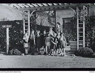 Ebisu, Japan. 1948-11-12. School pupils with their teacher Mrs J. Eastman outside the Australian Army Education Service school for BCOF children on Lae Road. All the roads in the camp have been ..