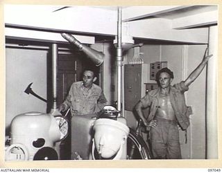 RABAUL, NEW BRITAIN. 1945-09-20. MR R. BARKER, PURSER OF THE ANDREW BRISCOE, THE FIRST VICTORY SHIP TO REACH RABAUL CARRYING SUPPLIES, SHOWING AN AUSTRALIAN SOLDIER OF 28 INFANTRY BATTALION OVER ..