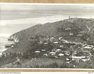 PORT MORESBY AREA, NEW GUINEA. 1943-12-29. THE TOWNSHIP OF PORT MORESBY NESTLING IN THE HOLLOW BEHIND PAGA POINT. ON THE TOP OF THE POINT CAN BE SEEN THE RADIO LOCATION STATION AND IMMEDIATELY ..