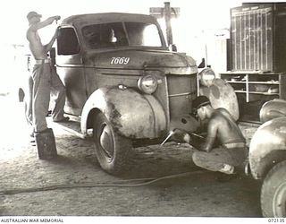 PORT MORESBY, NEW GUINEA. 1944-04-10. Q101248 CRAFTSMAN C. EVERDELL (1), AND QX50039 STAFF-SERGEANT C.A. MILES (2), PANEL BEATING AND WELDING A TRUCK AT THE 11TH ADVANCED WORKSHOP, AUSTRALIAN ..