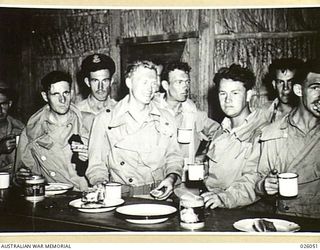 PAPUA, NEW GUINEA. 1942-07-27. JUST IN FROM A FLIGHT, AUSTRALIAN FIGHTER PILOTS HAVE A MEAL AT THE 'DROME "HEMBERGER HUT"