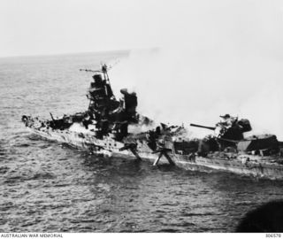 MIDWAY, PACIFIC ISLANDS. 1942-06-06. THE JAPANESE CRUISER MIKUMA, ON FIRE AND SINKING FOLLOWING ATTACKS BY US AIRCRAFT. NOTE THE TORPEDO TUBES PROTRUDING FROM HER HULL, THE RESULT OF THE EXPLOSION ..