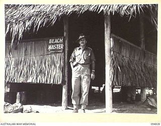 TOL, NEW BRITAIN, 1945-08-04. CAPTAIN M.E. JOSEPH, BEACHMASTER, HEADQUARTERS 13 INFANTRY BRIGADE, OUTSIDE HIS HUT AT TOL WHARF. HE WAS POSTED TO THE UNIT AS TRANSPORT OFFICER AND LATER FUNCTIONED ..