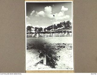 BOMANA WAR CEMETERY, PAPUA, NEW GUINEA. 1943-12-29. CLOSE UP OF THE GRAVE OF PENDIL A. RAYNER, AN AUSTRALIAN WAR CORRESPONDENT WHO WAS KILLED IN AN AIRCRAFT CRASH, SHOWING FUNERAL PARTY FROM THE ..