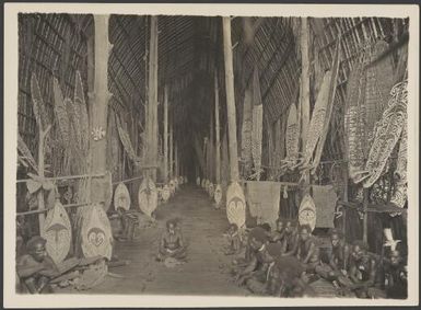 Men gathered in a longhouse, Kaimari village, Urama Island, Papua New Guinea, ca. 1922 / Frank Hurley