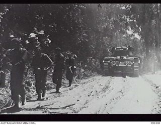 BOUGAINVILLE, 1945-04-05. A MATILDA TANK ADVANCING ALONG BUIN ROAD, SUPPORTED BY TROOPS OF 61ST INFANTRY BATTALION IN ORDER TO CLEAR THE ROAD BETWEEN B ECHELON, 25TH INFANTRY BATTALION HQ AND ..