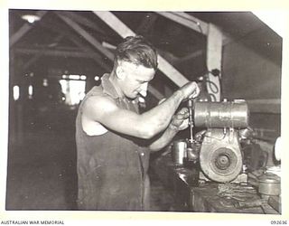 PURUATA ISLAND, SOUTH BOUGAINVILLE. 1945-05-29. CORPORAL TUOHY, 42 LANDING CRAFT COMPANY, REPAIRING A REFRIGERATOR PUMP. THIS COMPANY HAS PLAYED AN IMPORTANT PART IN SUPPLYING FORWARD AREAS DURING ..