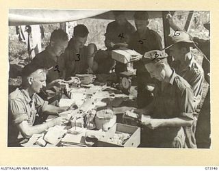 ALEXISHAFEN, NEW GUINEA. 1944-05-12. FIELD POST OFFICE NO.156 AT HEADQUARTERS 8TH INFANTRY BRIGADE. REPRESENTATIVES FROM UNITS (ON THE RIGHT OF THE TABLE) ARE COLLECTING MAIL. AT THE LEFT ..