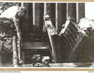 SCARLET BEACH AREA, NEW GUINEA. 1943-12-21. SX23513 CRAFTSMAN A. R. COUZNER (1) AND NX146578 TROOPER F. K. BRUTON (2) BOTH OF THE 1ST AUSTRALIAN TANK BATTALION GROUP WORKSHOP, AUSTRALIAN ELECTRICAL ..