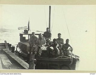 LAE, NEW GUINEA. 1944-08-14. CREW MEMBERS OF THE LAUNCH OF THE 12TH SMALL SHIPS COMPANY ABOARD THEIR CRAFT. IN THE BACKGROUND CAN BE SEEN THE 2/1ST HOSPITAL SHIP, "MANUNDA"
