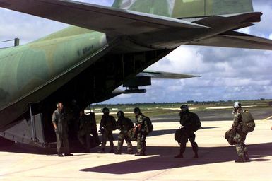 Left side rear view medium shot of the tail section on a USAF C-130 Hercules as US Marines from 2nd Platoon, Company A, 5th Force Reconnaissance Battalion, 3rd Marine Division, walk up the rear entrance of the cargo plane before performing a 6-thousand foot combat jump during the Force Reconnaissance Exercises at Andersen Air Force Base, Guam